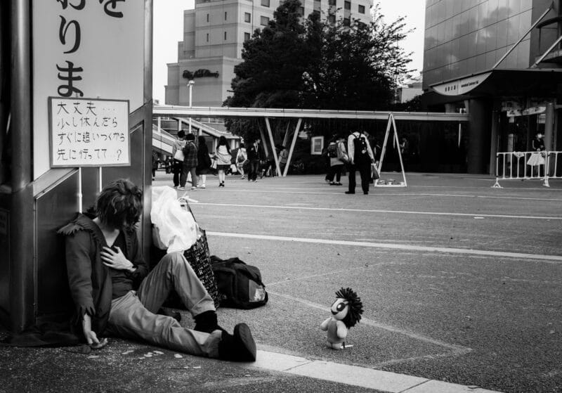 疲れて地面に座り込む男性の写真